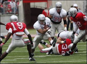 Dan Herron of the Gray team runs toward Orhian Johnson (19) of the Scarlet team in Saturday's spring game at Ohio Stadium which drew 65,223 fans.