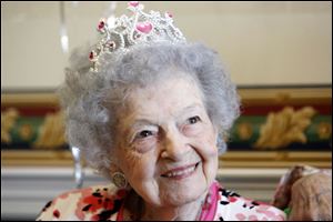 Olive Lauer wears a crown as she marks her birthday at Kingston of Sylvania, where she is learning French and winning at cards.