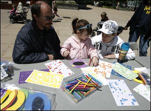 CTY zoo10p  Kaydie (cq) Otey (cq), 5, is the center of it all as she makes a picture frame for her mom. Helping her are dad Brian, left, and brother Cory (cq) 15. The Oteys live in Sylvania. The Toledo Zoo hosts moms for free and offers an opportunity to create a picture frame or card for mom as part of their annual  Mother's Day at the Toledo Zoo in Toledo, Ohio on May 9, 2010. Jetta Fraser/Toledo Blade