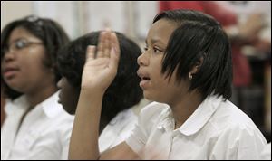 Nakkia Lampkin, a sixth-grade student at Stewart Academy for Girls, waves to a class in South Africa, seen on a computer link. Students shared differences and similarities in their respective schools, thanks to Skype, a computer communications program.