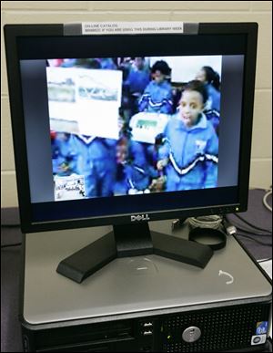 A computer link beams students attending class at Sol Plaatje Primary School in Mmabatho, South Africa, into Stewart Academy for Girls in Toledo. 