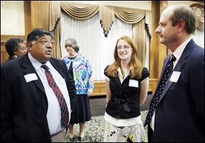 Bob Vasquez, president of the Toledo school board, left, and Start High School salutatorian Laura Zielinski, center, and her father, Paul Zielinski, discuss Miss Zielinski's plans for college.