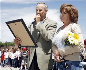 Toledo Councilman Tom Waniewski reads a proclamation dedicating the ballfi eld to
Jim Cherry, a local parent active in coaching, as his widow, Nancy Cherry, looks on.