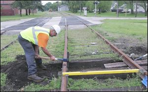 Randy Rood of Bowling Green swings away to repair railroad tracks along Michigan Avenue in Waterville. He has been honored by the Ohio Rail Tourism Association for his volunteer work.