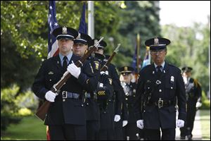 Toledo Police Department honor guard members Mike Talton, left, and Al Cavanaugh present the colors at the ceremony.