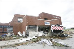 A vehicle rests on its top at the severly damaged Lake High School.
