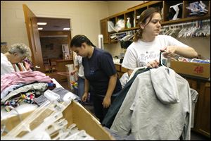 Krystal Harms, 17, left, and Emily Keil, 18, help sort clothing for tornado victims at Mainstreet Church. Both are Lake High School graduating seniors.