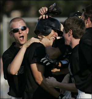 Perrysburg's David Gordon, center, is congratulated by Alex Williams, left, and other teammates after driving in the game-winning run against Southview.