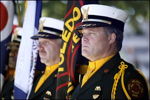 Toledo Fire and Rescue Honor Guard, from right, Jeff Koenigseker, Craig Ellis, and Robert Parker stand at attention for the event.