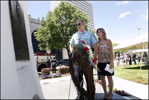 Toledo Police Officer Jeffery Bechtel and Kerry Beeler scan the Last Alarm Memorial for the name of Officer Bechtel's father, Glenn E. Carter, who died in 1961 after the Anthony Wayne Trail fire. 