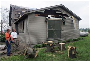 Larry Lewis shows U.S. Rep. Bob Latta the damage during the lawmaker's tour of what was the epicenter of Saturday night's tornado, Fulton County Road 7.  