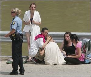 A group of teens show concern over one of their friends who was rushed to the hospital after he disappeared while swimming in the Maumee River Monday.