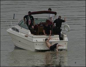 Toledo Fire Department rescuers help an unidentified teen who swam to a nearby island after Craig A. Seymour disappeared in the river.