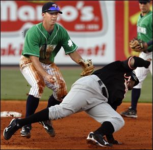 Mud Hens shortstop Brent Dlugach tags out Norfolk's Josh Bell during a run down in the fourth inning of Thursday's game at Fifth Third Field.