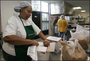 Viveca Crews, Mr. Baker's
sister, prepares brown sugar
for the sauce. 