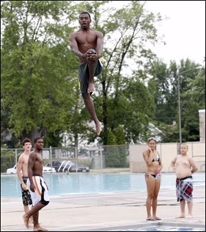 Lifeguard Dennis Garrett flexes to perform a cannonball while on break at Willys Park pool. 