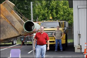 Rick Roe of Wauseon watches the path of a pipe carried by a front-end loader as it negotiates a rebar obstacle course.