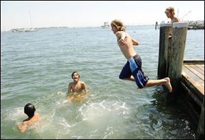 A group of boys finds respite in the Mystic River, in eastern Connecticut. Beaches across the region were jammed Monday as temperatures neared dangerous levels.
