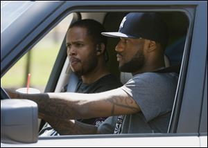 LeBron James drives away with Damon Jones after a workout at the University of Akron. All eyes will be on James at 9 p.m. Thursday.