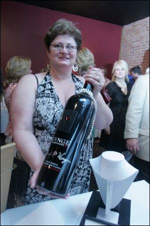 Bobbee Clawson holds a large bottle of wine that was up for auction at the Beach House fund-raising event.<br>
<img src=http://www.toledoblade.com/graphics/icons/photo.gif> <font color=red><b>NEW IMAGES:</b></font> <a href=