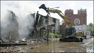 Demolition of the former Tate Funeral Service and an adjacent structure in the 1000 block of Broadway after a fire ripped through the vacant buildnig. The fire is being investigated as arson.