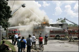 Toledo firefighters battle a blaze suspected to be arson at the former Tate Funeral Service on Broadway. 