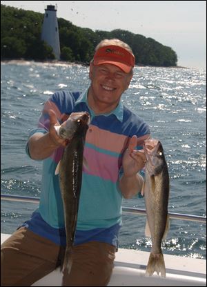 Gov. Ted Strickland shows off two walleye he landed during Lake Erie Governor's Fish Ohio Day. 