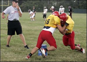 Brad Lutchman, assistant football coach at Ottawa Hills, watches twins Corey, left, and Codey Tyda of Bowlng Green during practice for the 20th annual Regional All-Star Game.