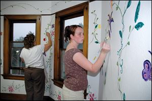 A Lourdes College art student paints a mural in the Padua House during the College‘s Week of Service.
