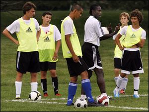 Dennis Bailey, middle right, of the English Premier League gives instructions to local players at Pacesetter Park in Sylvania. 