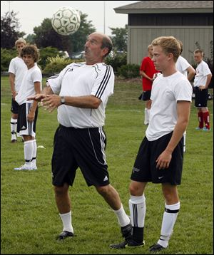Des Davies demontrates a move as Logan Glosser of Ottawa Hills watches.
