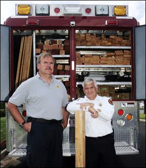 The equipment truck's lumber storage area provides a backdrop for two team members, Jerusalem Township Fire Chief Harold Stanton, left and Thomas Jaksetic, a battalion fire chief with the Toledo Fire Department.