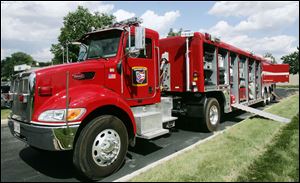The unit's tractor-trailer equipment rig carries gear including saws, hand tools, air-monitoring devices, ropes, tarps, inflatable lift bags, and lumber.