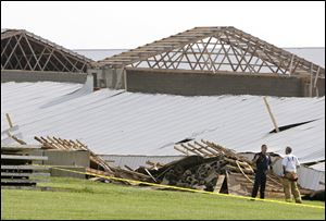 Firefighters survey the scene of a buliding collapse at Ohio Fresh Eggs in central Ohio, where two people were killed Wednesday.