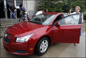 

Congressman Marcy Kaptur gives a thumbs-up after arriving at GM Toledo Powertrain in a red, four-door Chevy Cruze that she drove from the nearby Miracle Mile Shopping Center. 