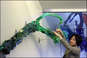 Artist Sayaka Ganz works on the 58-foot long sculpture 'RE-surgence,' in the Huntington Center.