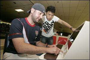 Central Catholic special needs teacher Ryan Titkemeier, left, and foreign exchange student Apai 'Joe' Aursoontorn, 18, of Thailand go over their scores while bowling at Southwyck Lanes.