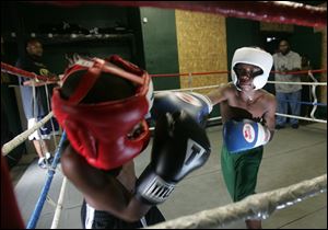 Ta'loun Nedd, 9, left, spars with Otha at Soul City Boxing Gym at Belmont and Junction Avenues. The academy has 15 students ages 7 to 22. 