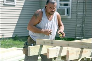 Charles Brewer measures and marks a board for the ramp. Four more ramps are planned this year in Monroe County.