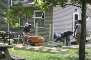 Mike Smith, AFL-CIO community services liaison to the United Way of Monroe County, said that the cost to build each ramp is about $2,000, well below the estimated $6,000 it would cost to build if lumber, nails, and other materials were not donated.

Erie Grocery Store-IGA; Tad Cousino, owner of the Frog Leg Inn, and the Monroe County Correction Officers Union provided in-kind donations such as pizza, beverages, and cups and plates for the volunteers who showed up for Mr. Barron's ramp.

At the same time volunteers were at Mr. Barron's home, another crew or union carpenters from the same local were tackling a ramp outside a home on Virginia Court in Monroe.

Mr. Smith said the program plans to build four more ramps this year in Monroe County.

In addition to the unionized skilled trades, juvenile offenders at the Monroe County Youth Center help on the ramp projects.

Mr. Smith said the teenagers work with professionals to gain exposure to a trade that could help give them the skills to improve their lives as they move forward.