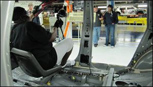 A device known as the Happy Seat, on a moveable robot arm, enables employees of Chrusler's Belvidere, Ill., assembly plant to see where they are attaching air bags inside vehicles.