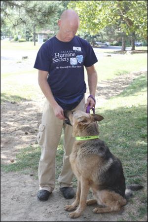 Staff member John Brown gives Sarge a treat at the Toledo Area Humane Society.