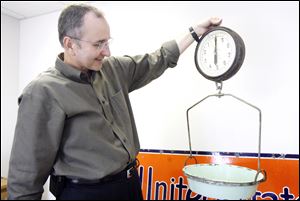 Robin Horvath, Packo's chief operating officer, holds the original scale that his grandparents used to measure spices. The concoction was mixed in the basement of the restaurant on Front Street. 
