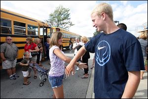 Jordyn Taylor, 13, and Benjamin Swartz, 15, greet each other before boarding a bus for a shopping spree for young tornado victims at JC penny and Aeropostale at the Shops at Fallen Timbers.