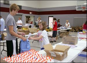 NBRN packs25p  8/18//2010 The Blade/Lisa Dutton Lambertville,MI l to r-- Devin Hice,15 of Bedford, gets rulers put into his backpacks by Victoria Dierks,10 of Lambertville,MI. Volunteers will be sorting and packing school supplies that were collected over the last month for the annual back-to-school backpack program. Get pictures of the volunteers with the supplies. The backpacks will be distributed this week. The volunteers will begin at 9 a.m.