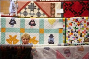 SLUG:  NBRE QUILTS19                   8/19/2010 The Blade/Amy E. Voigt        Pemberville, Ohio                                                          CAPTION:  Bonnie Woods, from Bowling Green, looks at several quilts on display during the 2010 Pemberville Free-Fair Quilt Show on August 19, 2010.