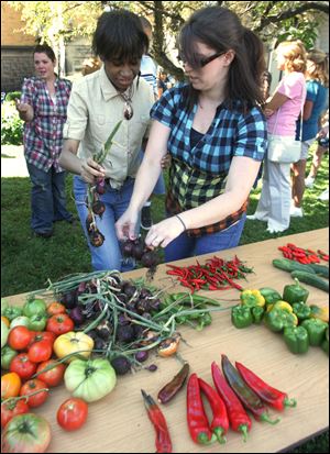 Latesha Bolden, left, is assisted by teacher aide Jessica Haley during the garden party where Latesha and her classmates harvested the vegetables. 
