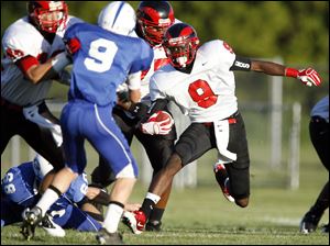 Rogers' DerJuan Gambrell, (9), cuts as Anthony Wayne's Jake Chipka (9) is blocked during the first quarter Friday night. 
