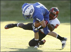 Anthony Wayne's Matt Granger, who rushed for 86 yards and a touchdown,is brought down by Antwon Dupree of Rogers. 

