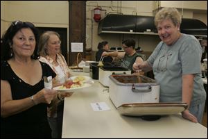 Kathy Jarret, left, and Jen Teschner line up for some spaghetti being served by Lyn Moeltner, right foreground, and Cathie Slabaugh during the fund-raiser to benefit church custodian Tony Leno, who is still hospitalized.